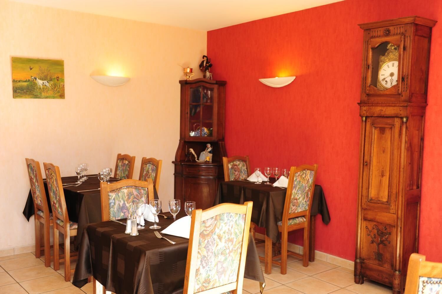 Ein Esszimmer mit roter Wand, einem Holzschrank und einer Uhr.