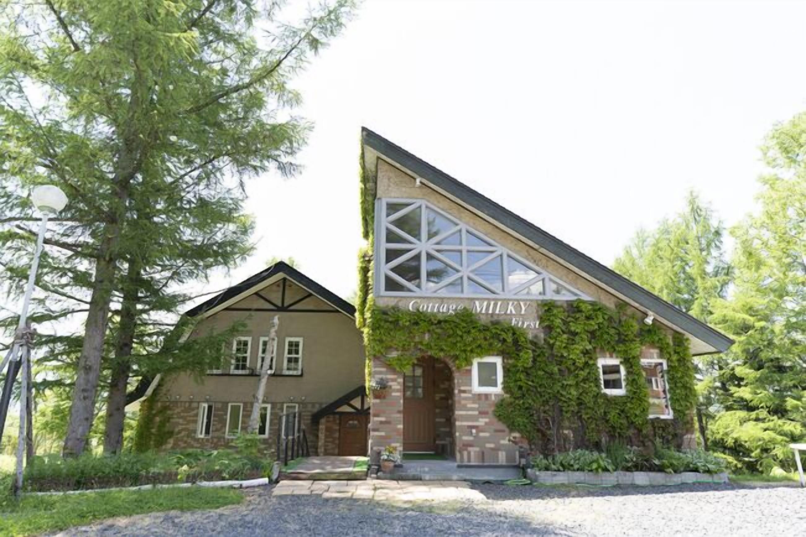 A two-story building with a sign reading 'Cottage MILKY First.'