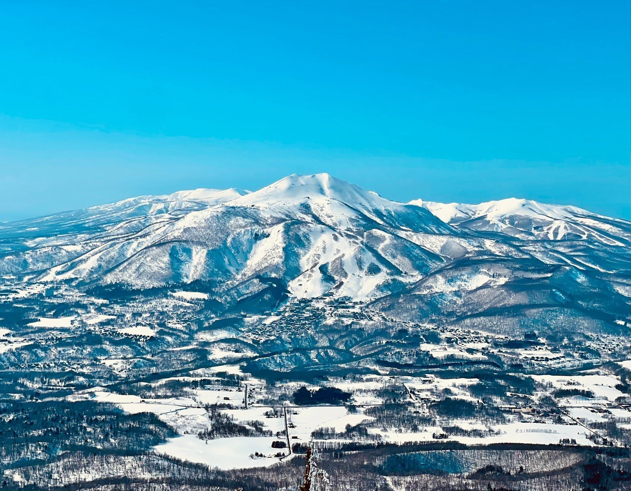 A snow-covered mountain with a town at its base.