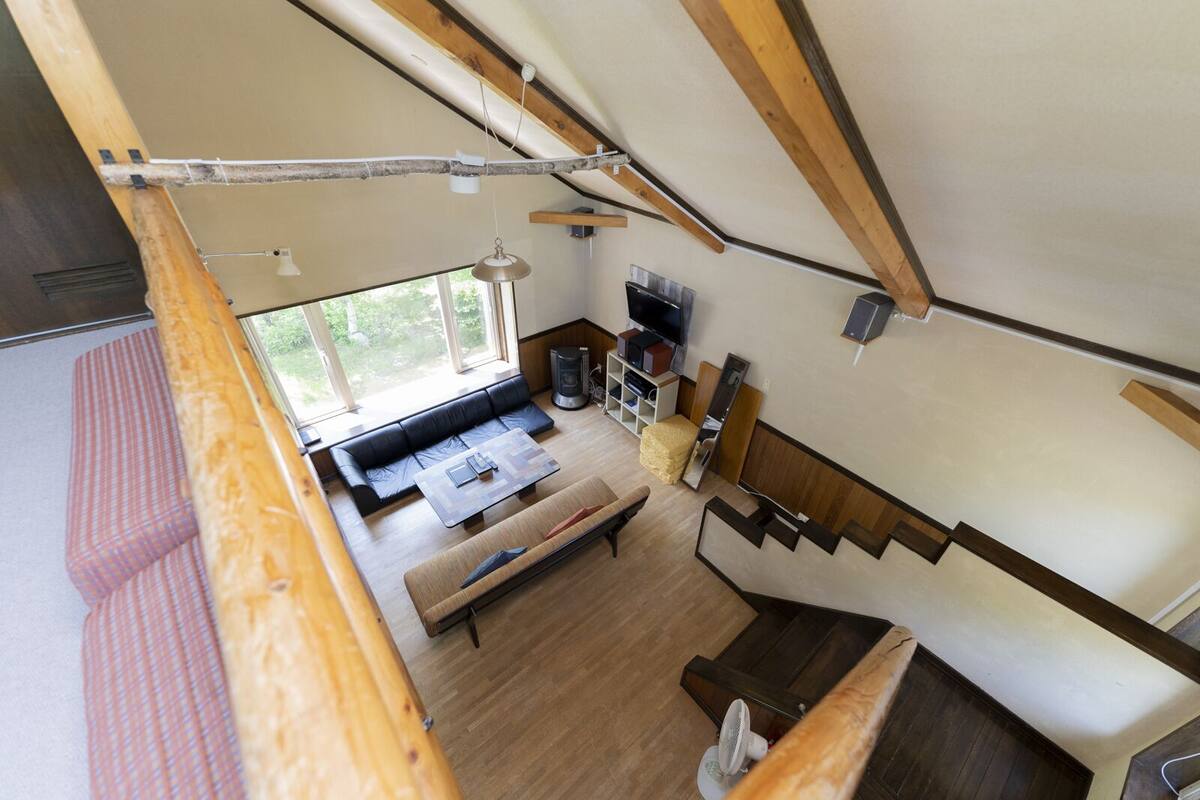 Un espace de vie compact comprenant une chambre en mezzanine, un coin repas et une cuisine.