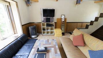 Un espacio de sala acogedor con un sofá, una mesa de centro, un televisor y una chimenea.