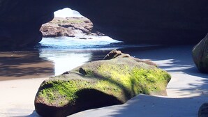 Nær stranden, sort sand og parasoller