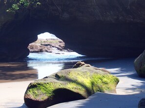Pantai di sekitar, pasir hitam, dan payung pantai