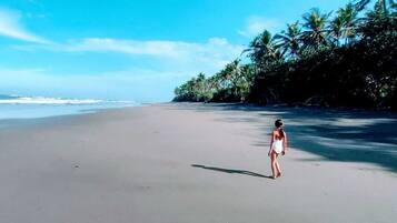 In StrandnÀhe, schwarzer Sandstrand, Sonnenschirme