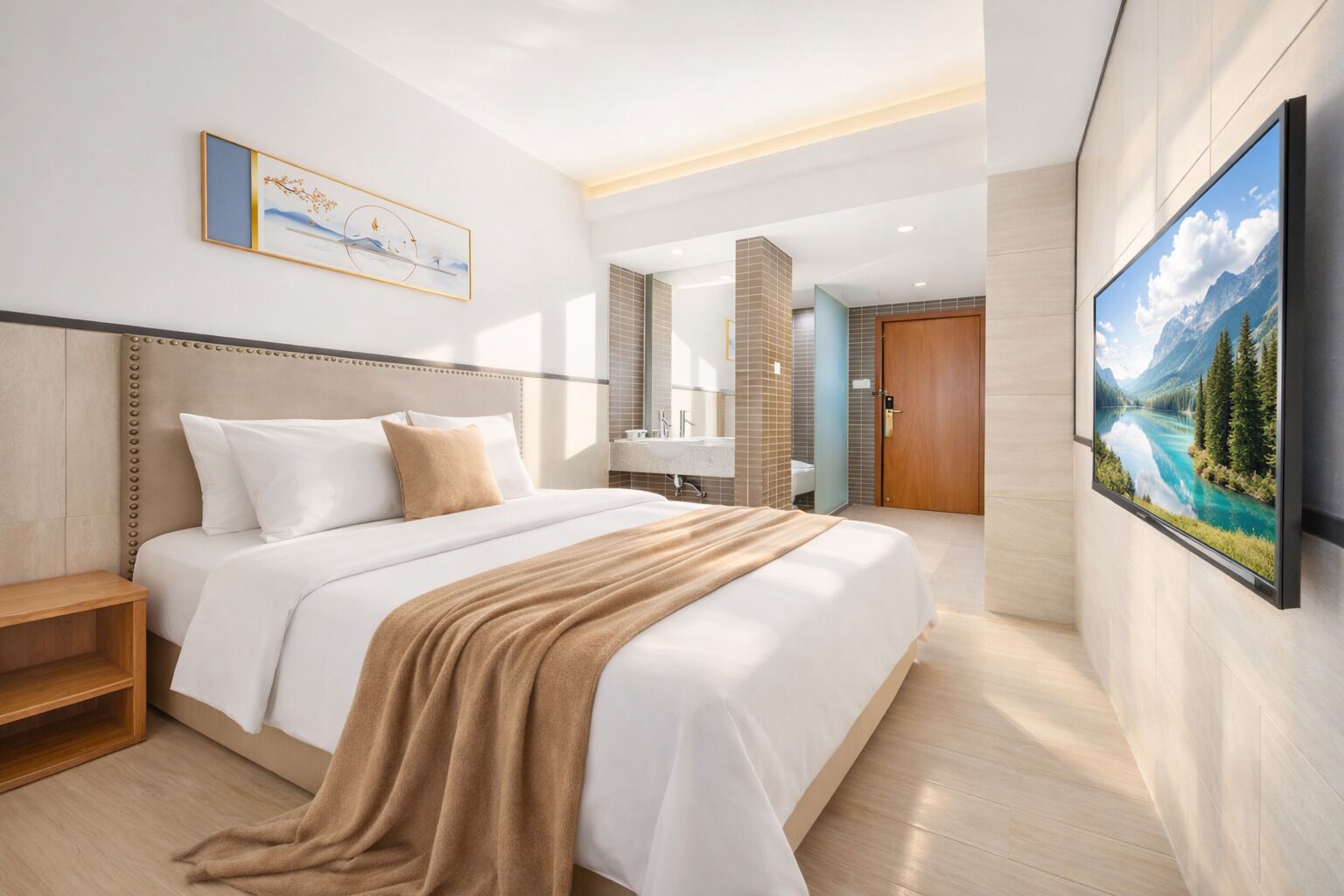 Ein Hotelzimmer mit einem großen Bett, einem Nachttisch, einem Badezimmer mit Waschbecken und Spiegel sowie einem an der Wand montierten Fernseher.