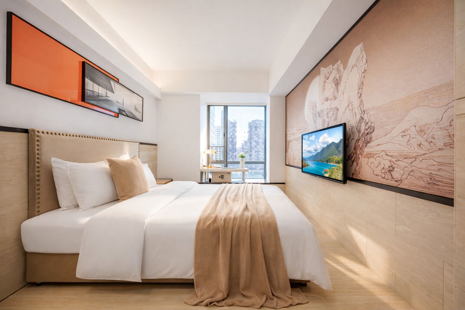 A hotel room with a bed, a TV, a large window, and artwork on the walls.