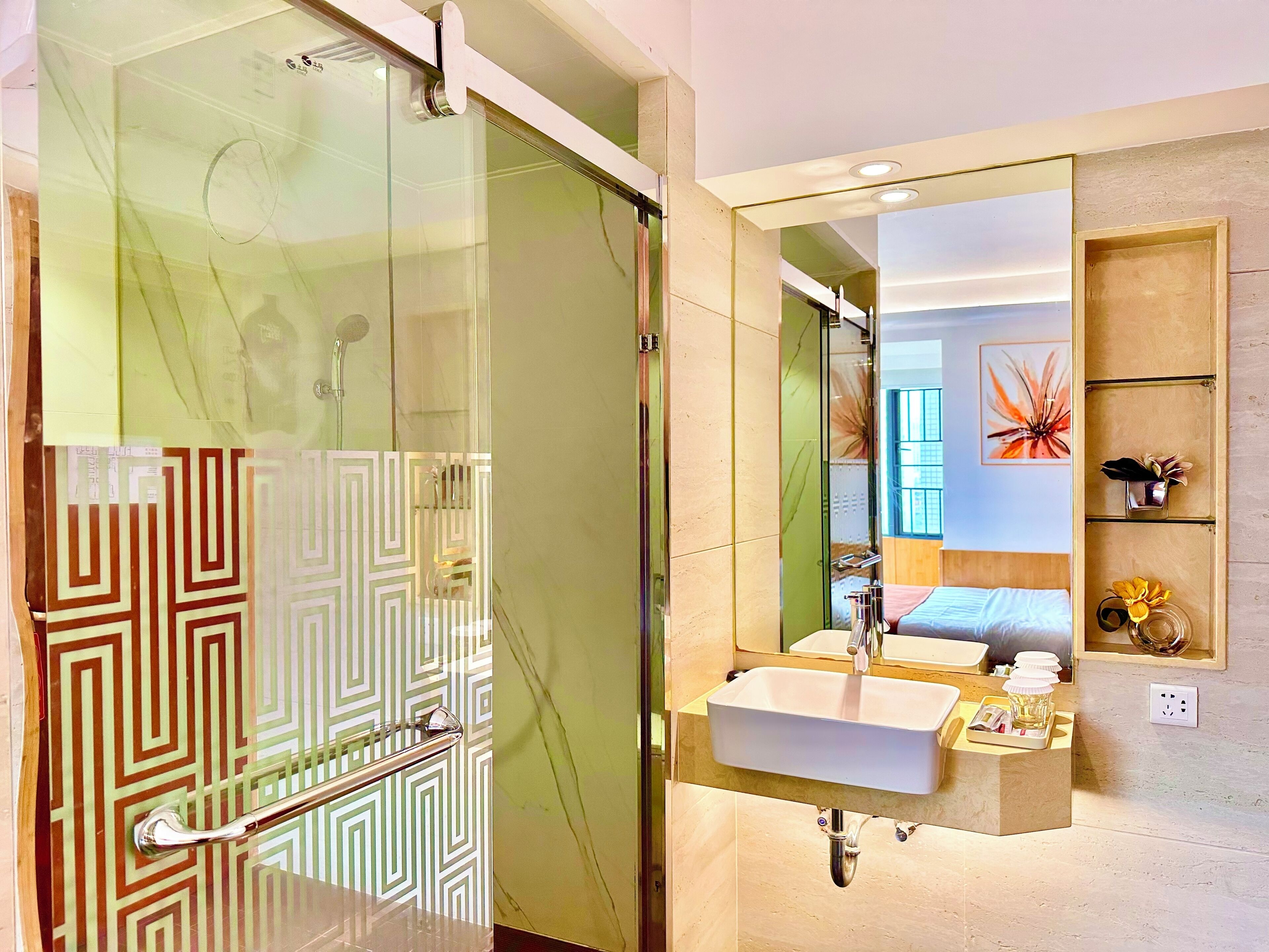 A modern bathroom with a glass shower enclosure, a vanity with a sink, and a mirror.