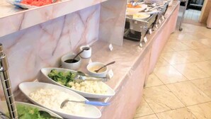 Un banco buffet con diversi cibi e utensili.