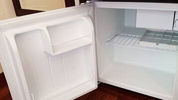 An open refrigerator with a freezer compartment on the right and a main compartment on the left.