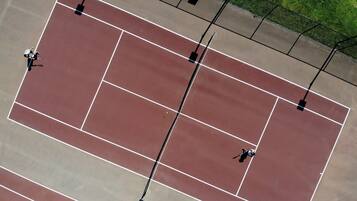 Luchtbeeld van een tennisbaan met lijnen die de grenzen en serveerboxen aangeven.