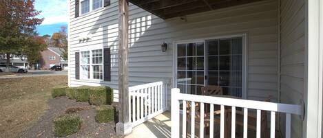 A two-story house with a front porch, a small deck, and a visible garage.