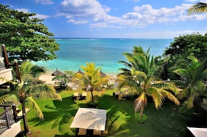 A tropical resort with a view of the ocean, palm trees, and a beach area. - Le Cardinal Exclusive Resort (Trou aux Biches)