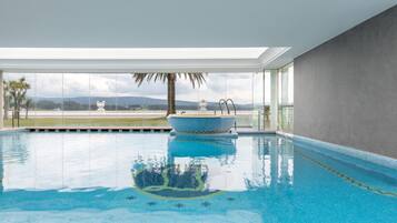 An indoor swimming pool with a clear view of the mountains in the background.