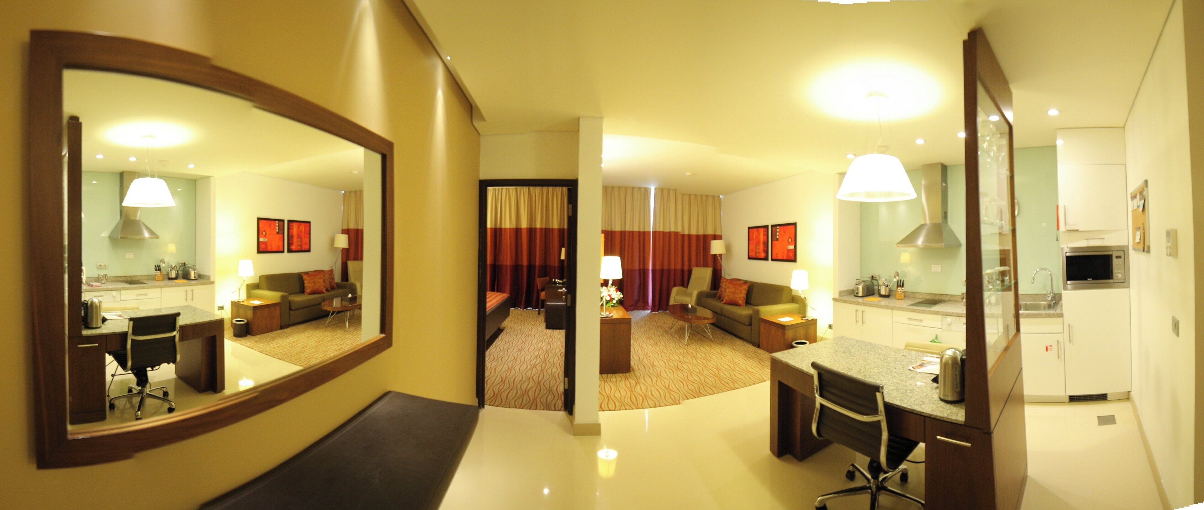 Una habitación de hotel con comedor, sala de estar y cocina.