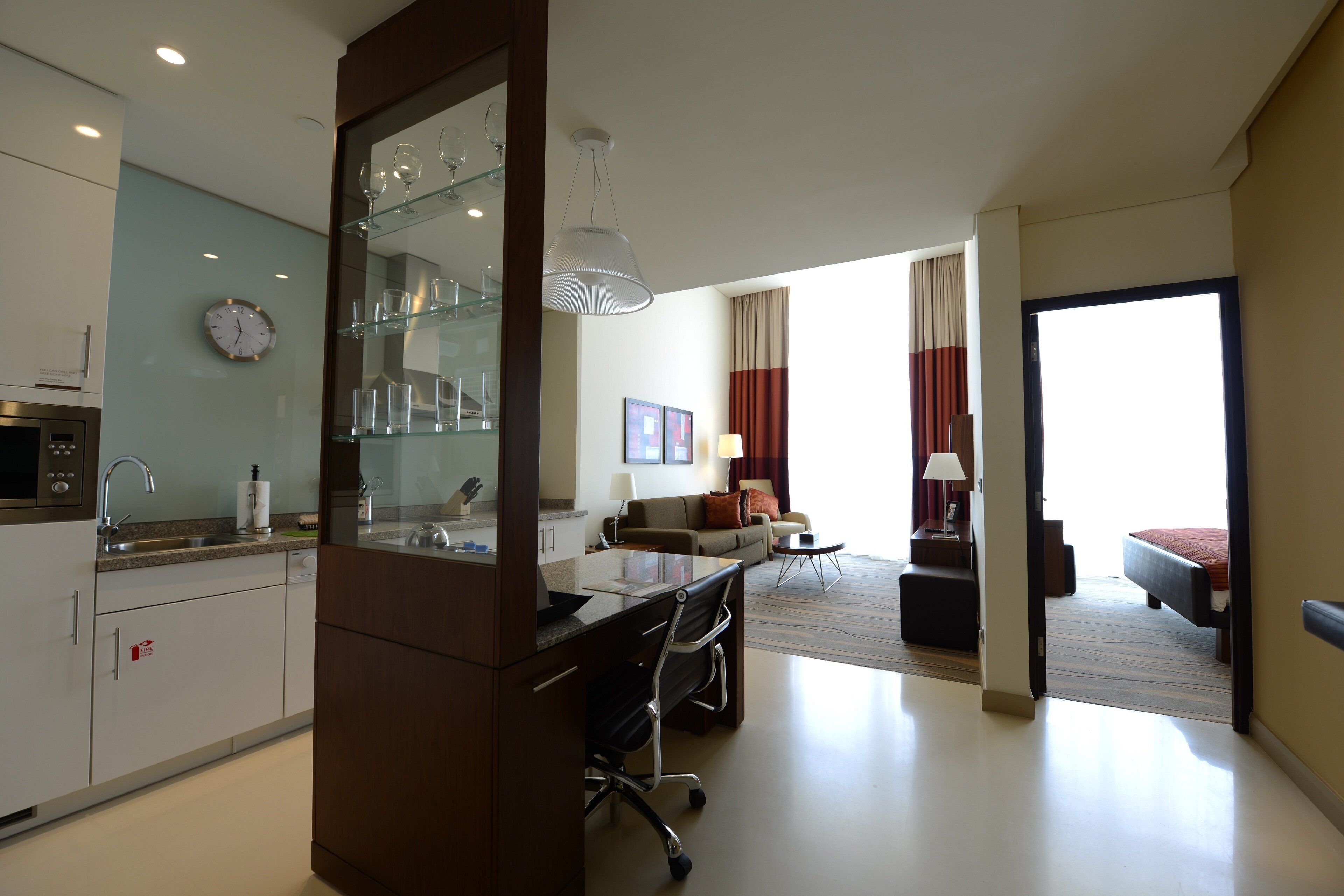 Una habitación de hotel moderna con kitchenette, zona de comedor y sala de estar.