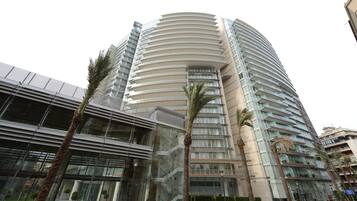 Un moderno edificio de gran altura con fachada curva, ventanas amplias y entrada de vidrio.