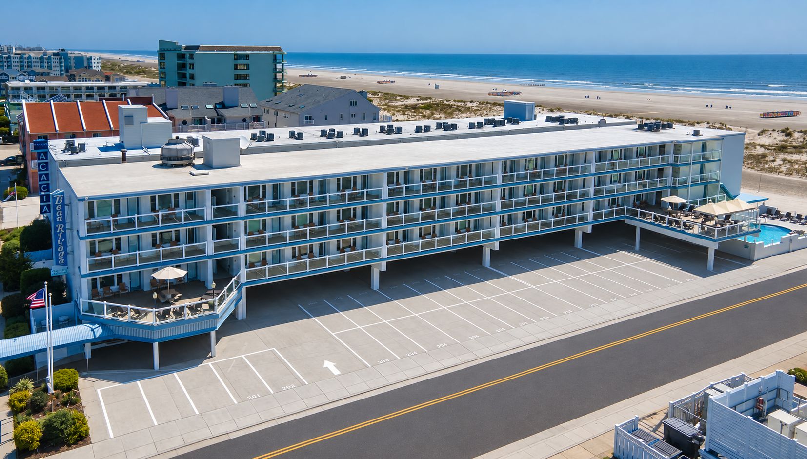 Un hôtel à plusieurs étages doté d’une piscine sur le toit et offrant une vue sur la plage.