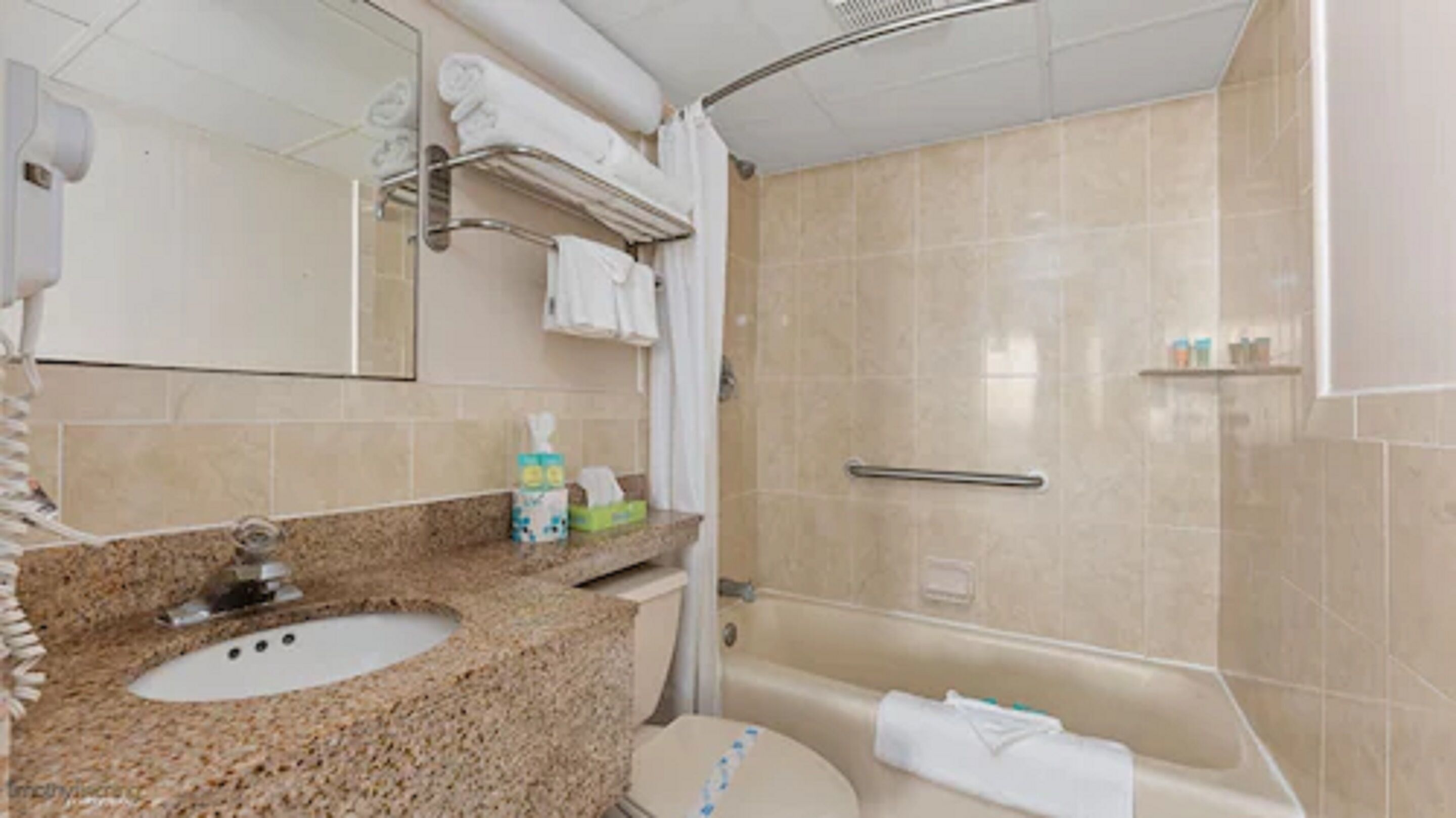 Une salle de bain équipée d’un lavabo en granit, de toilettes, d’une baignoire et d’une douche.