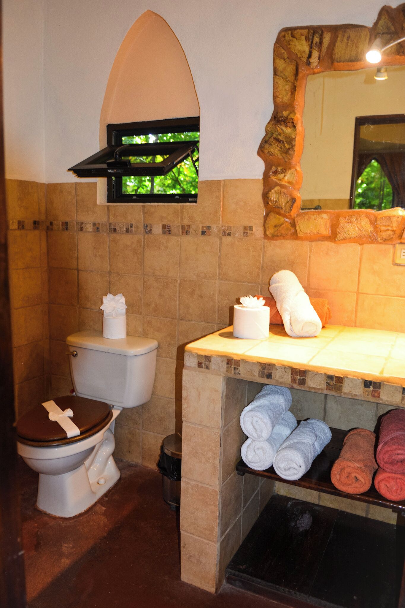 A bathroom with a toilet, a sink, and a towel rack with towels.