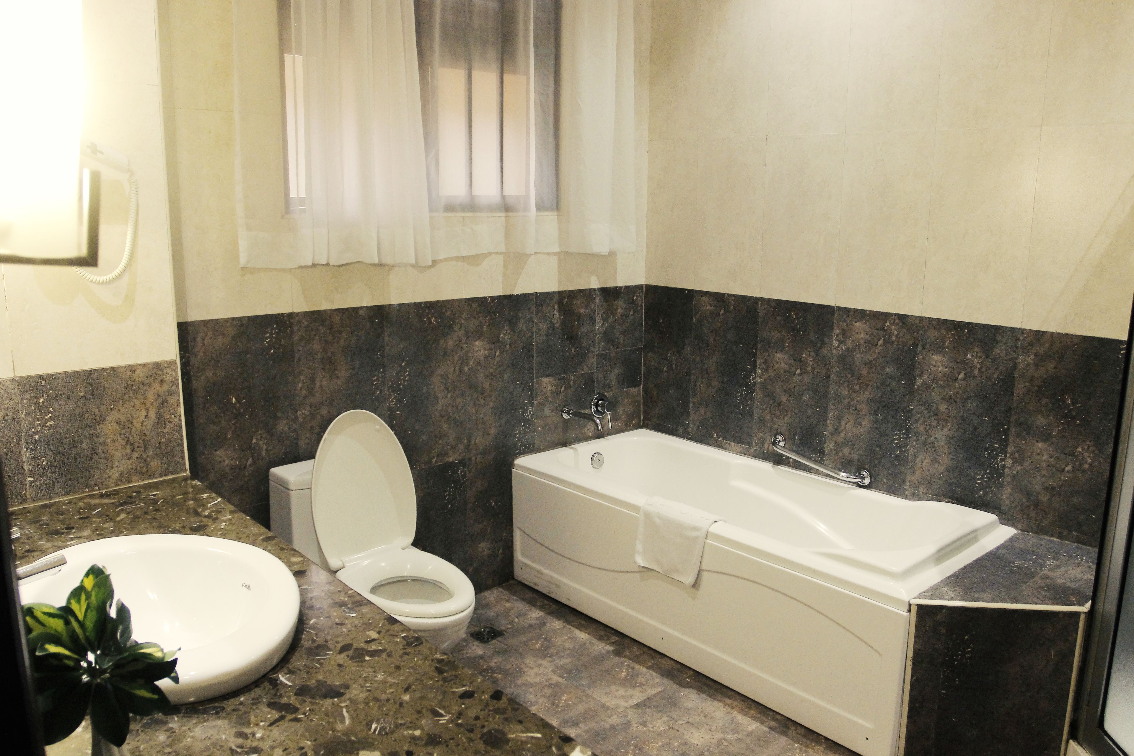 Un baño con una bañera blanca, un inodoro y un lavabo.