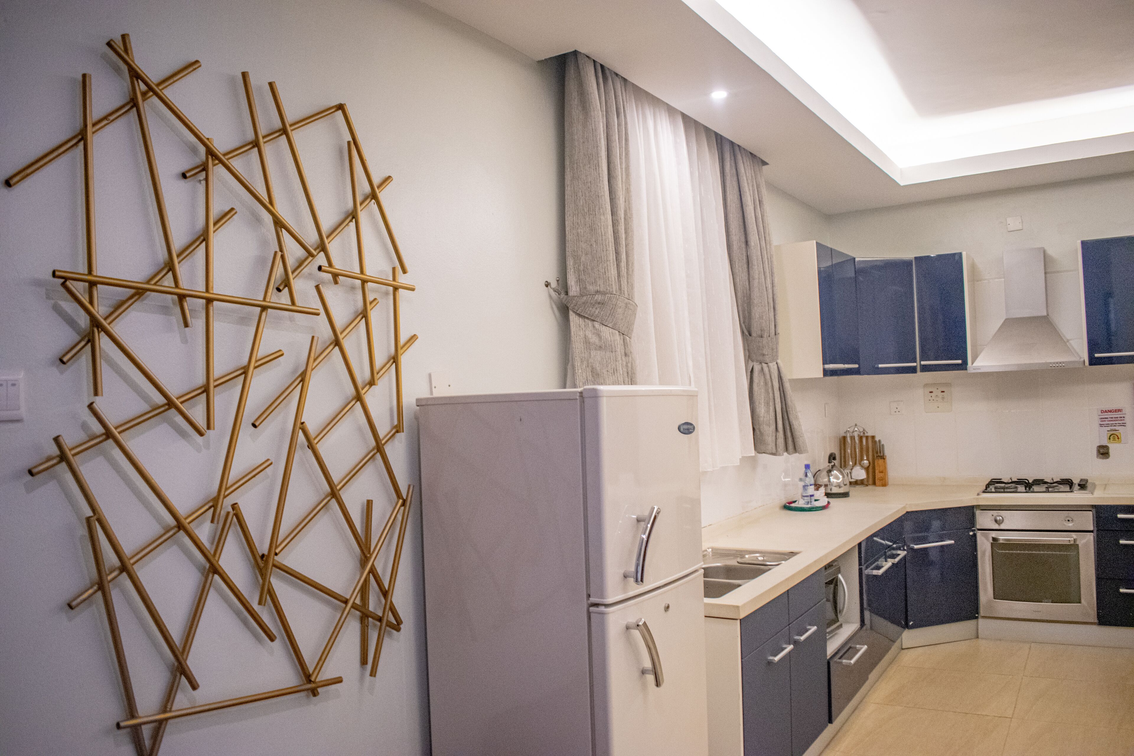 A modern kitchen with a refrigerator, stove, and cabinets.