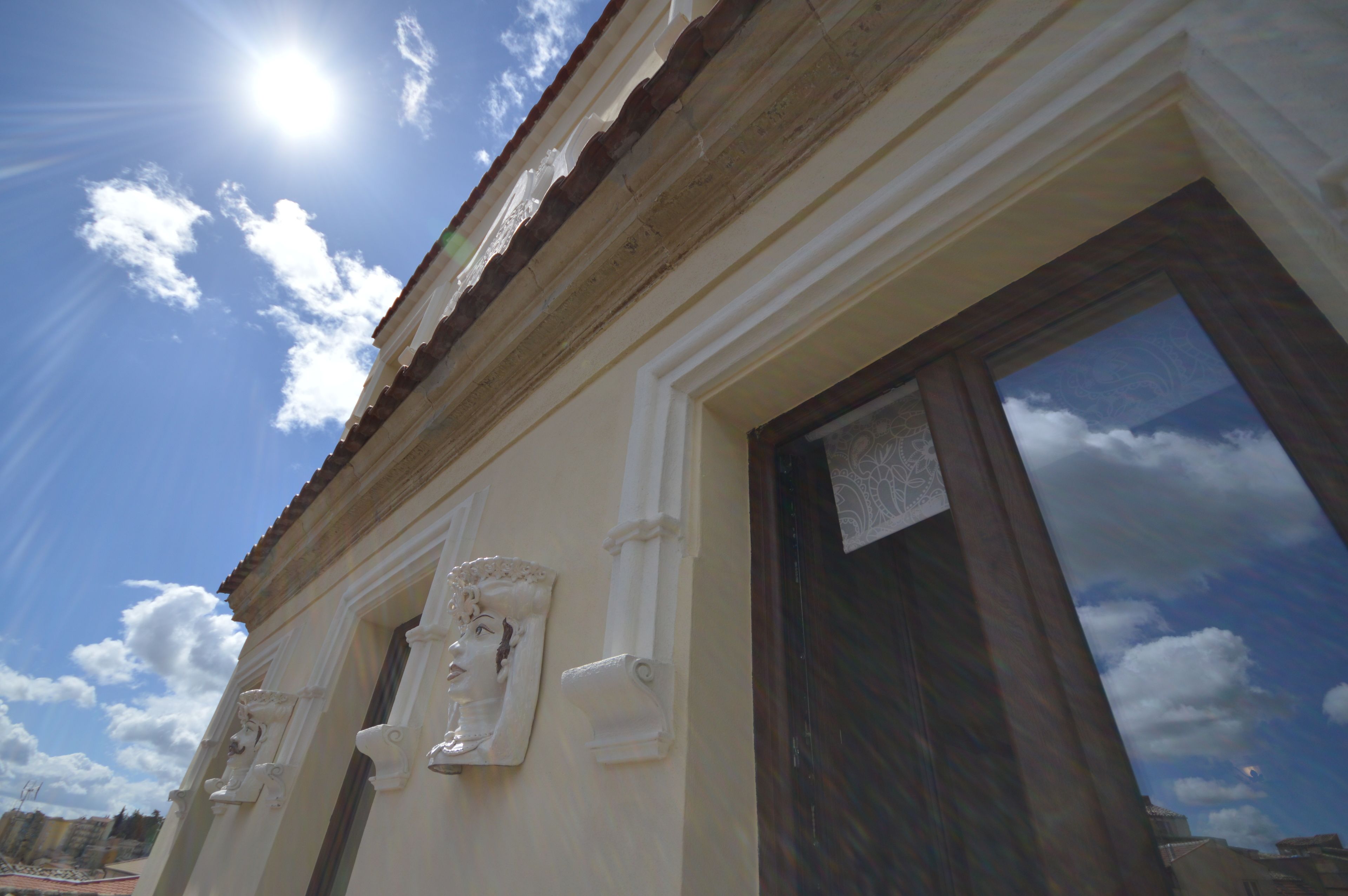 A building facade with classical architectural details, including a decorative window and a door with a glass panel.