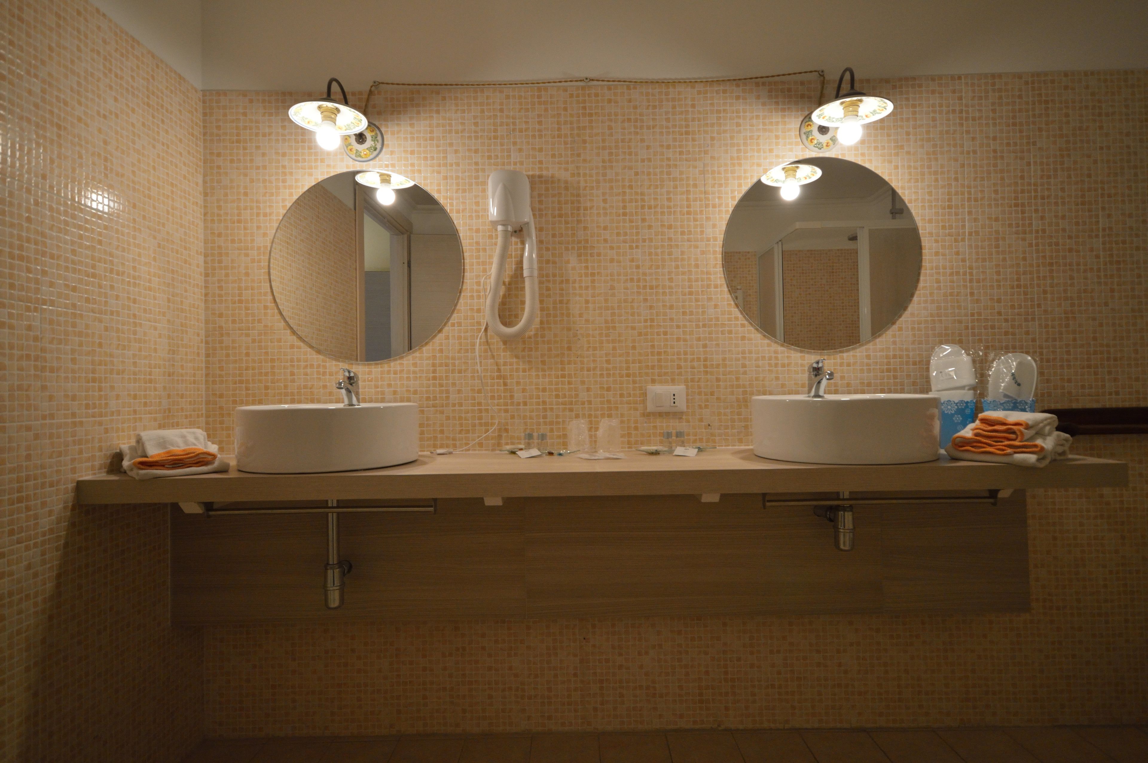 Un baño con dos lavamanos, un espejo y un perchero para toallas.