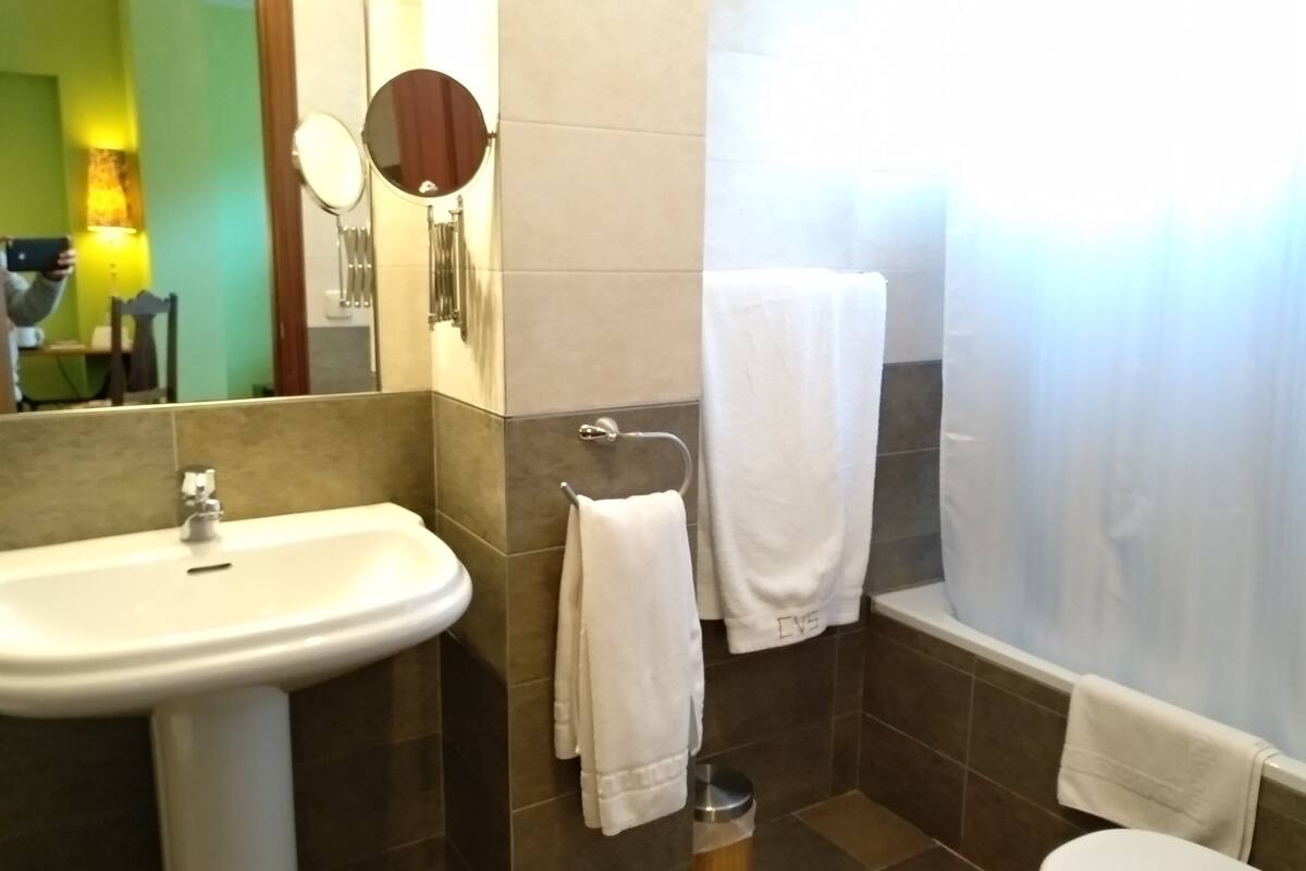 room with living room | bathroom | bathtub, free toiletries, hair dryer, towels