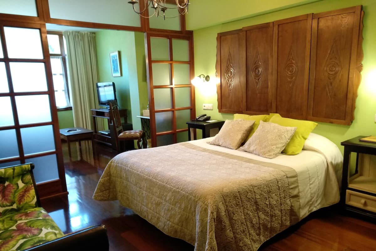 Une chambre de style japonais traditionnel, dotée d’un grand lit, d’une tête de lit en bois et de portes coulissantes.