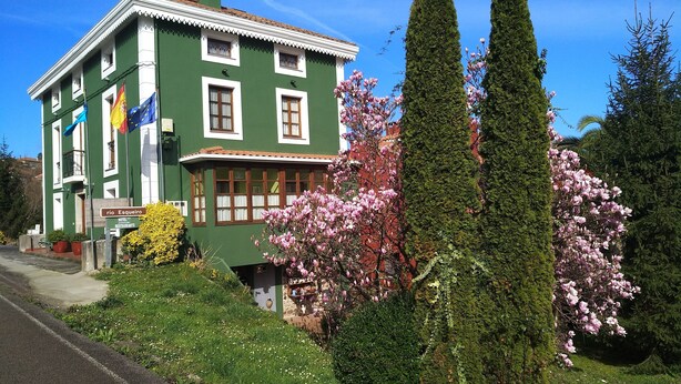 Il s'agit d'un bâtiment écologique, reconnaissable à une enseigne indiquant qu'il abrite un hôtel et un restaurant. On y trouve des arbres en fleurs et une pelouse bien entretenue à l'avant.