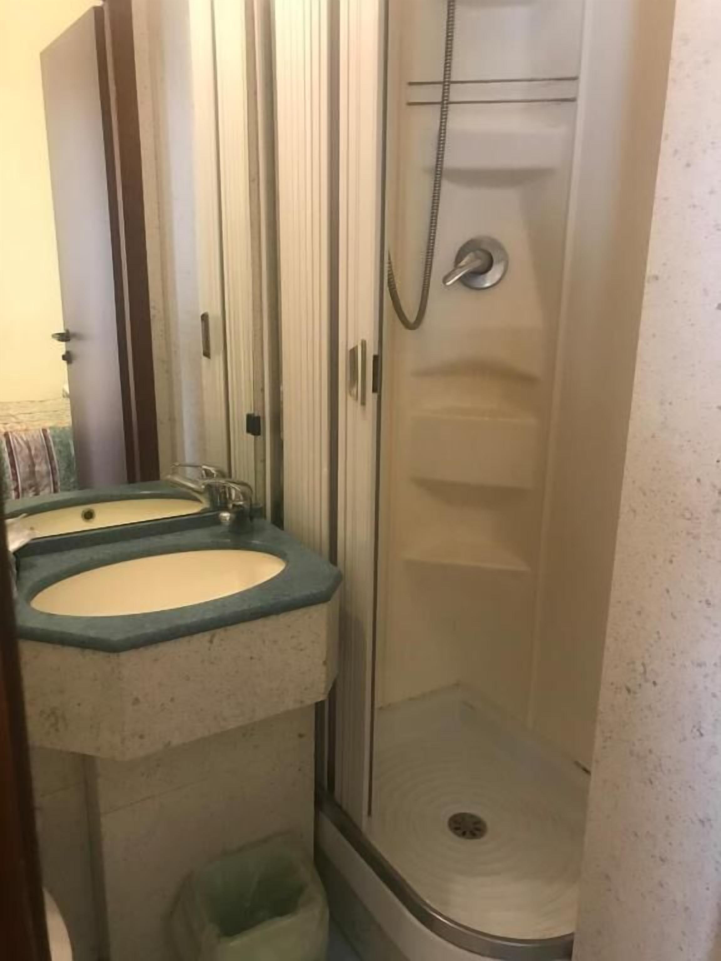 A bathroom with a shower, a sink, and a toilet.
