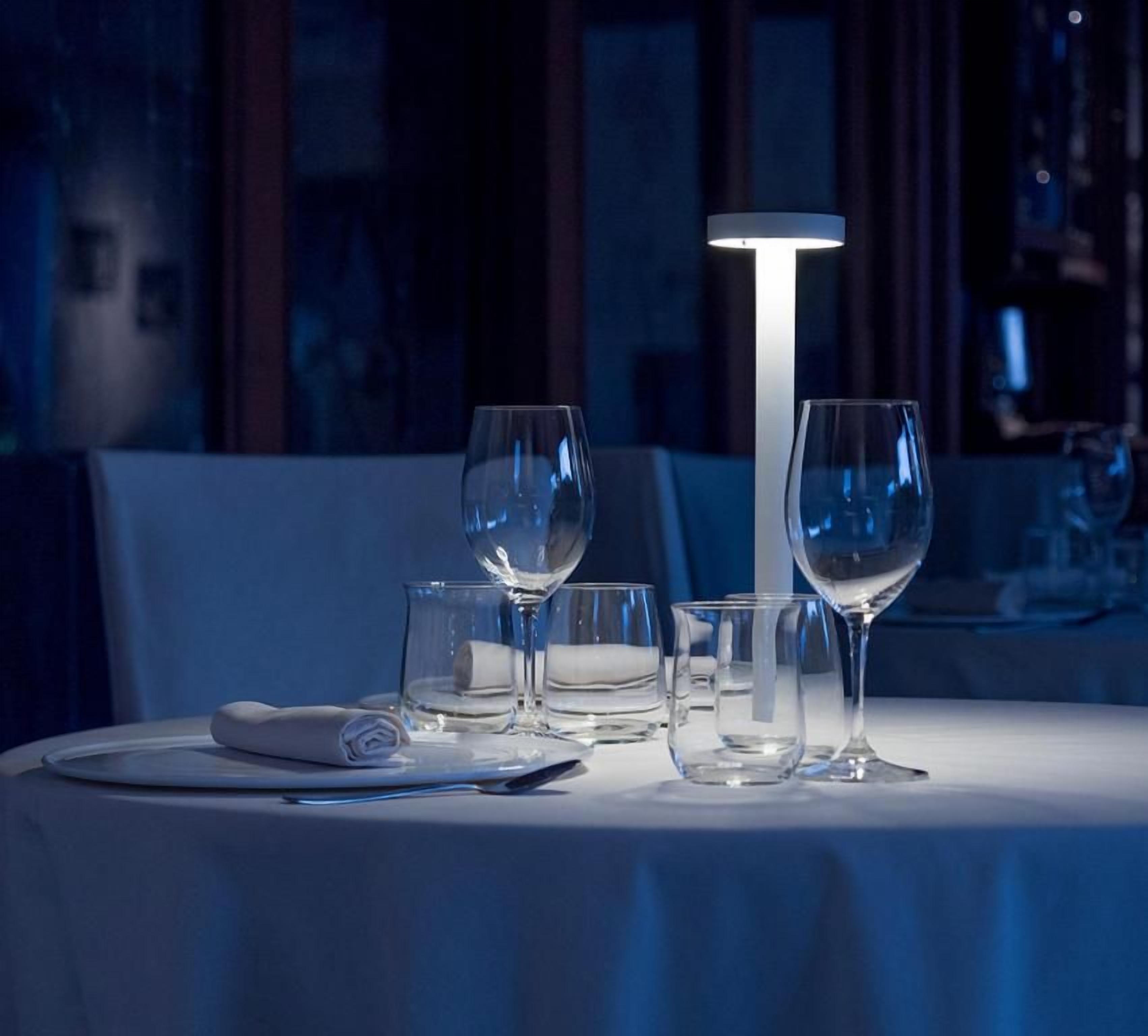 A table set with a white tablecloth, a folded napkin, and several empty wine glasses.