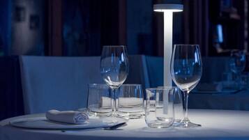 A table set with a white tablecloth, a folded napkin, and several empty wine glasses.