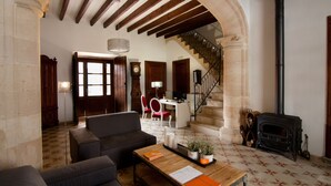 A spacious living area with a fireplace, a staircase, and a dining area. - Petit Hotel Algaida  (Algaida)