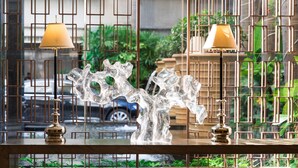 Une table avec deux lampes et une sculpture en verre décorative.