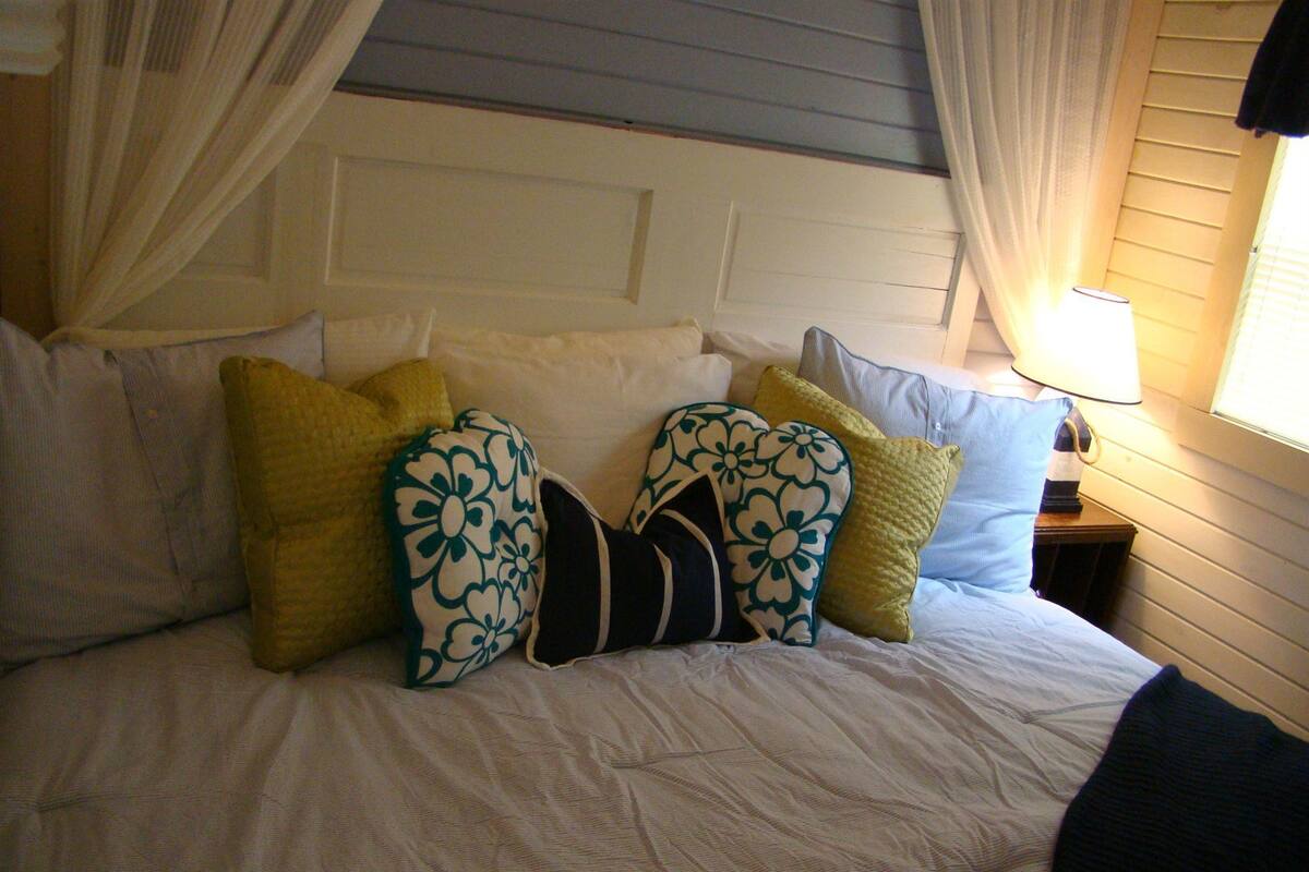 A bed with multiple pillows and a canopy.