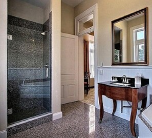 Bathroom features a glass-enclosed shower and a vanity with a mirror.