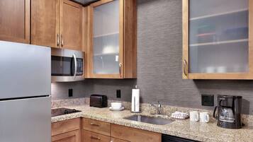 A modern kitchen with wooden cabinets, stainless steel appliances, granite countertops, and a dishwasher.