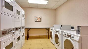 A laundry room with stacked dryers and a washing machine.