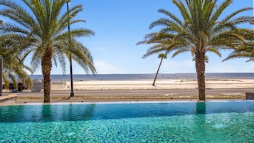 Een buitenzwembad, parasols voor strand/zwembad