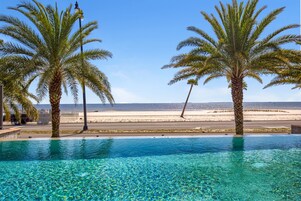 Una piscina al aire libre, sombrillas, sillones reclinables de piscina