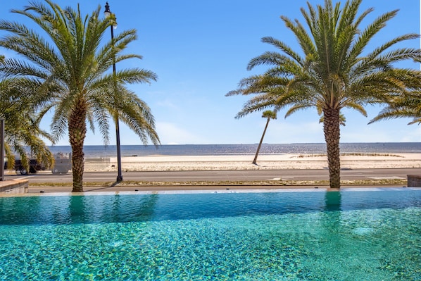 Una piscina al aire libre, sombrillas, sillones reclinables de piscina