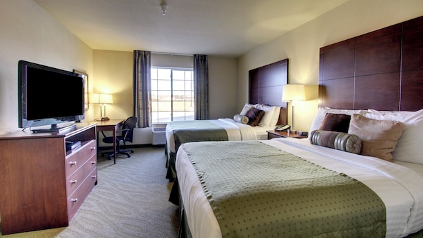 A hotel room with two beds, a desk, a TV, and a window. - Cobblestone Hotel & Suites - Wayne (Wayne)