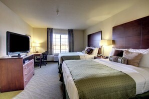 A hotel room with two beds, a desk, a TV, and a window. - Cobblestone Hotel & Suites - Wayne (Wayne)