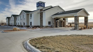 A hotel with a covered entrance, stone pillars, and a sign indicating it is the Cobblestone Hotel. - Cobblestone Hotel & Suites - Wayne (Wayne)