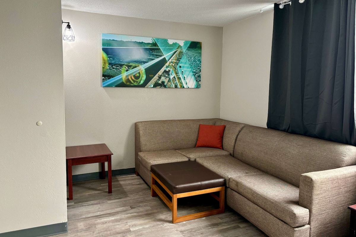 Ein Wohnzimmer mit einem beigen Sofa, einem kleinen Holztisch und einer Bank.
