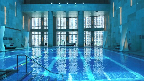 An indoor swimming pool with clear water, large windows, and modern architecture. - The Azure Ningbo, Vignette Collection by IHG (Ningbo)