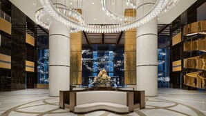 A spacious lobby with a central seating area, large columns, and a modern chandelier. - The Azure Ningbo, Vignette Collection by IHG (Ningbo)