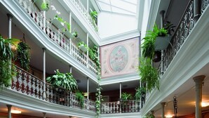 A multi-level atrium with balconies, potted plants, and a central fountain. - BLUME. - Baden Hotel & Restaurant (Baden)