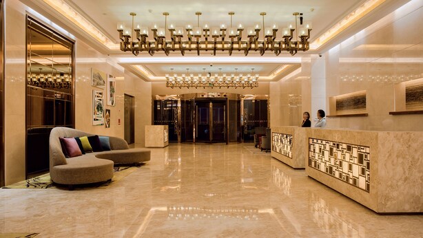 A spacious lobby with a marble floor, a reception desk, a large chandelier, and a sofa with colorful cushions. - Lia Chengdu Hotel (Chengdu)
